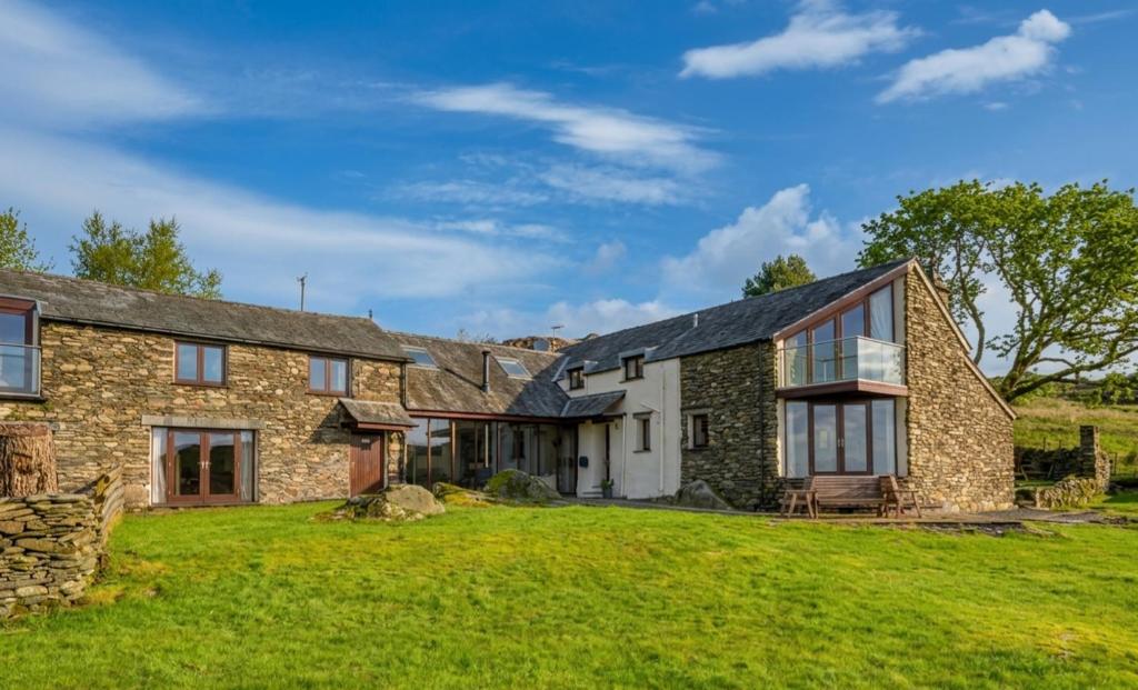 an exterior view of a stone house with a yard at Spacious Barn Conversion 4 Bedroom Hot Tub - Pass the Keys in Seathwaite