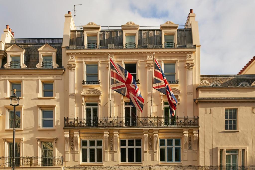 two british flags flying in front of a building at Haymarket Hotel, Firmdale Hotels in London