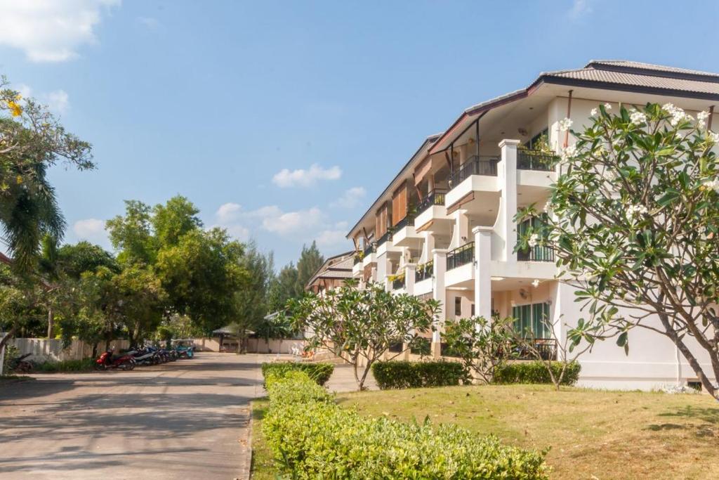 a white building with trees in front of it at Southern Lanta Apartments in Ko Lanta