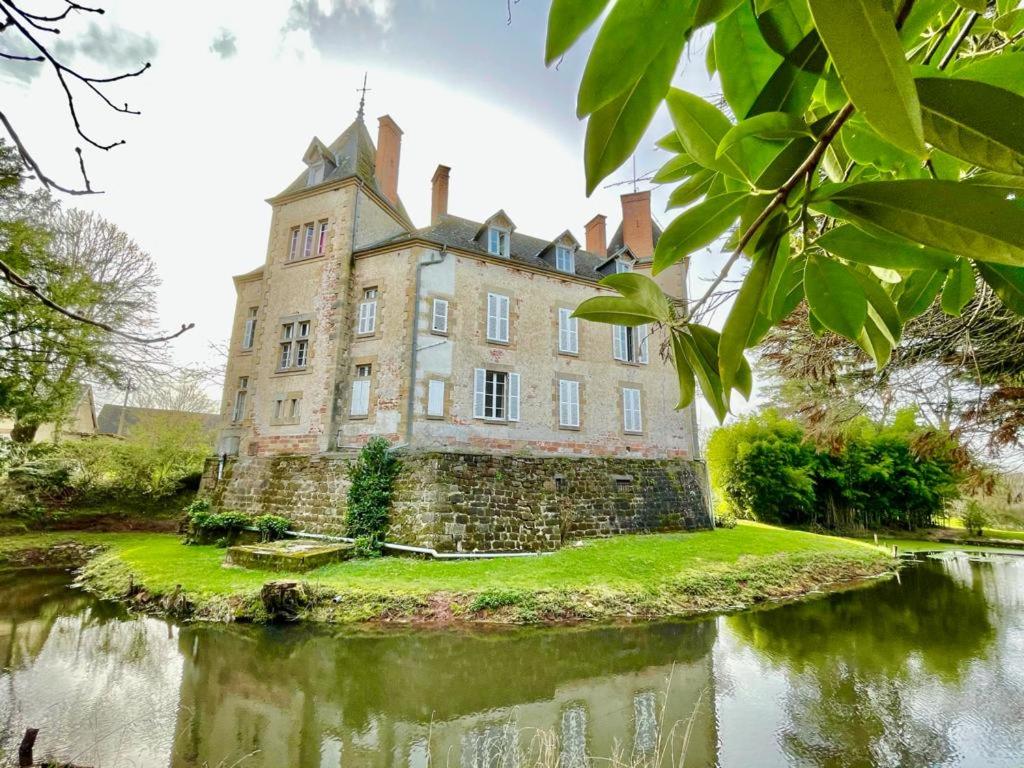 an old castle on an island in a body of water at Chateau de Bouquetraud in Franchesse