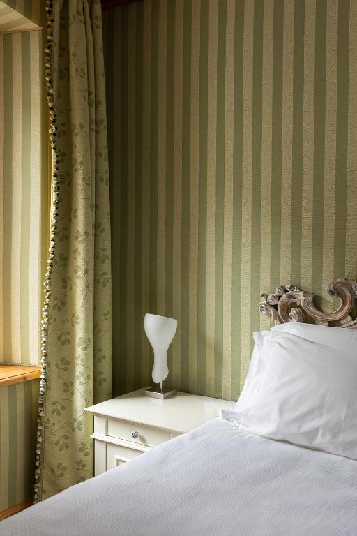a bedroom with a bed and a table with a lamp at Càdor Hotel in Valle di Cadore