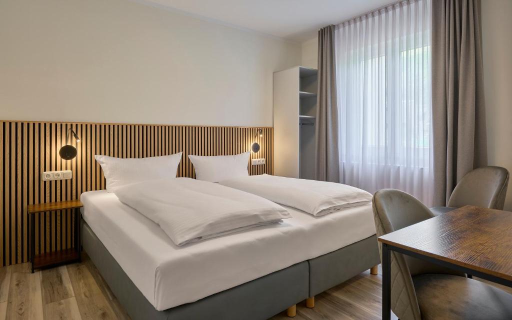 a hotel room with a bed and a table and a desk at Gästehaus am Weinberg in Oberheimbach