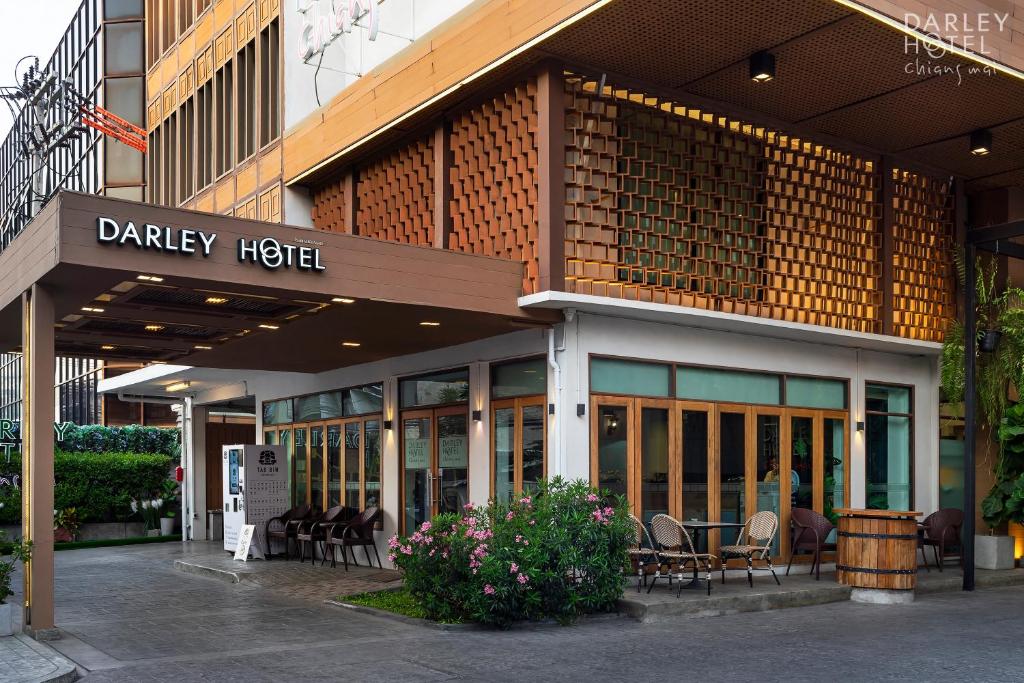 a davis hotel with chairs and tables outside of it at Darley Hotel Chiangmai in Chiang Mai