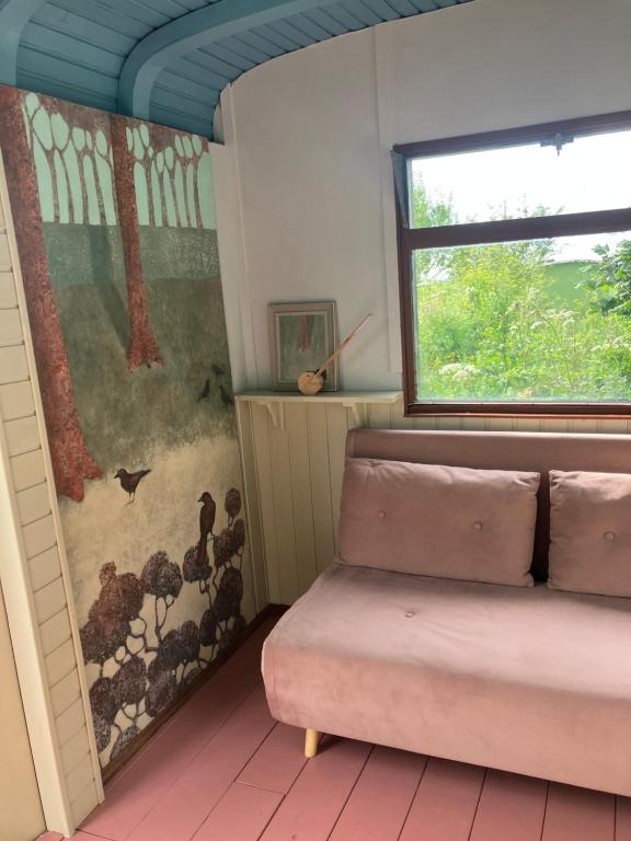 a room with a window and a pink ottoman at Klein Garnwerd 9 in Garnwerd