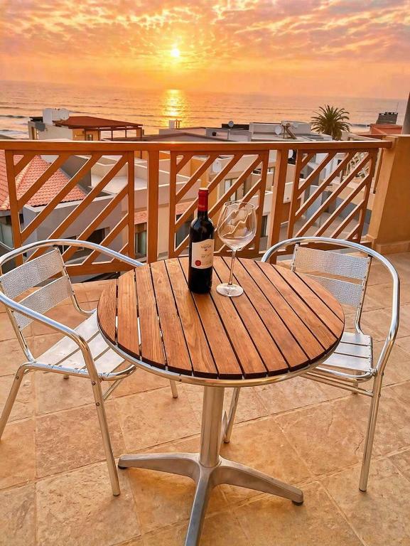 a bottle of wine sitting on a table with two chairs at Dolphin View 34 in Langstrand