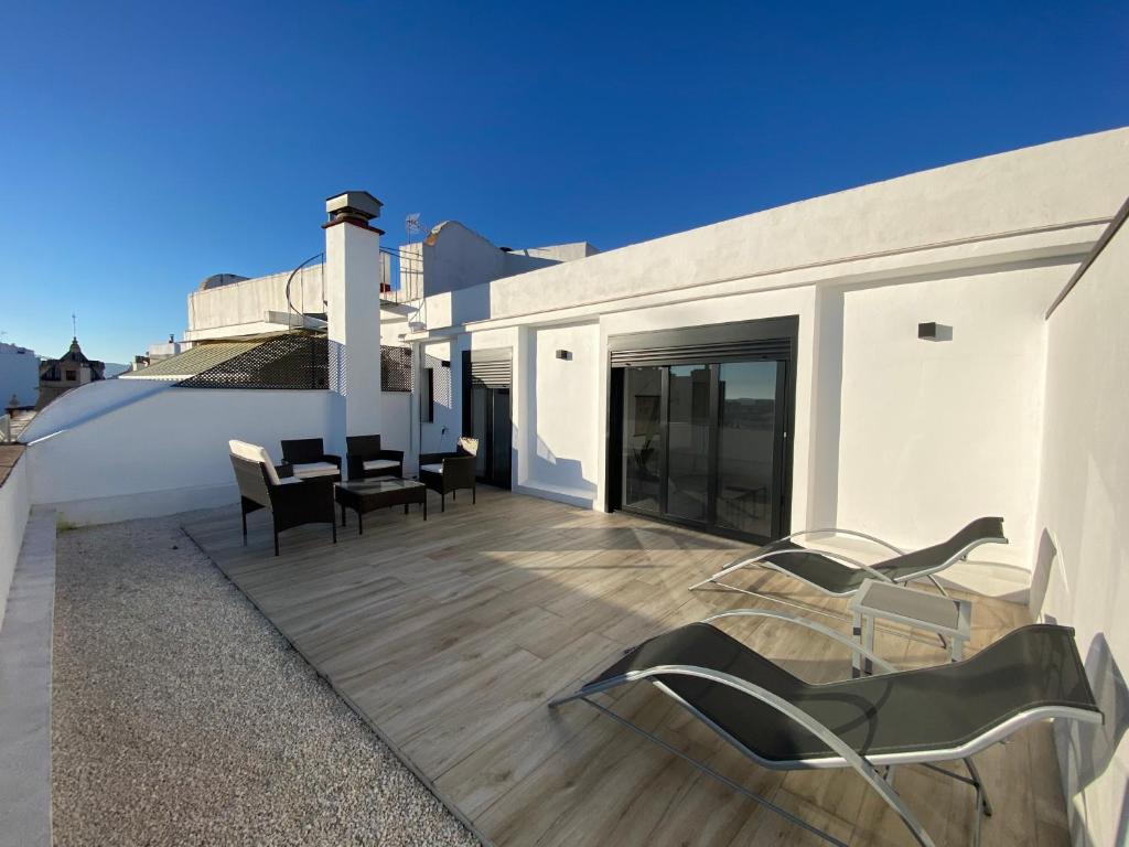 a balcony with chairs and tables on a building at Aticos Concepción Centro in Córdoba