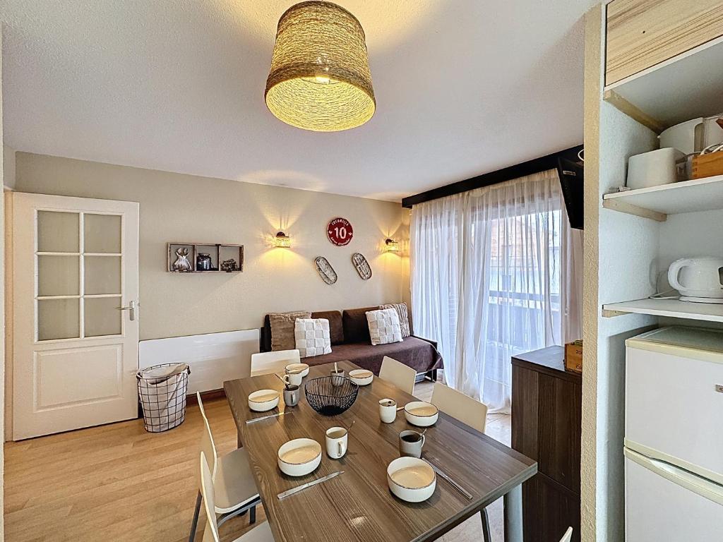 a kitchen and living room with a wooden table at L'Eterlou by Mountain Collection Immobilier in Saint-Chaffrey