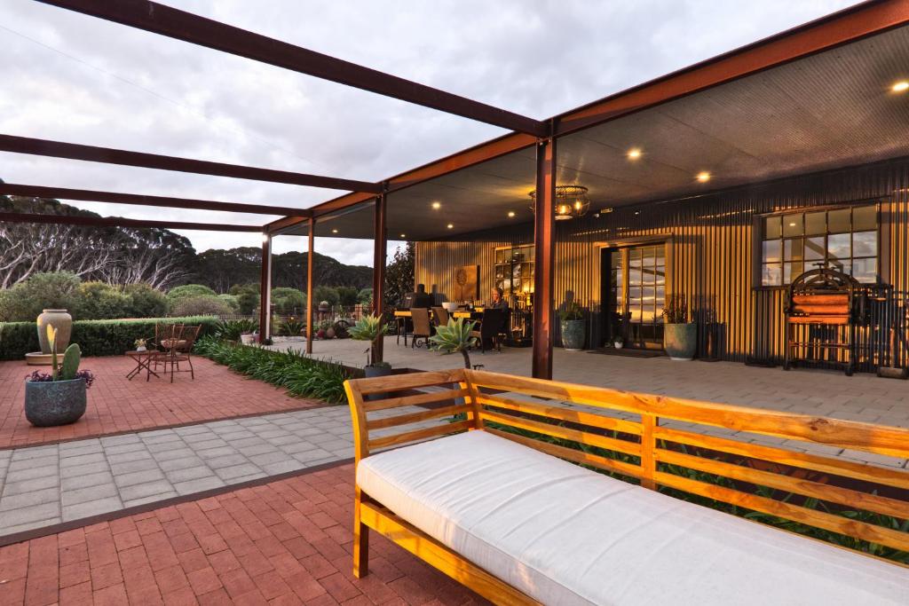 a wooden bench sitting on a patio at The Rusty Kangaroo Hideaway - Ocean-View - Full Booking Service, Ferry, Experiences, Tour Option in Penneshaw
