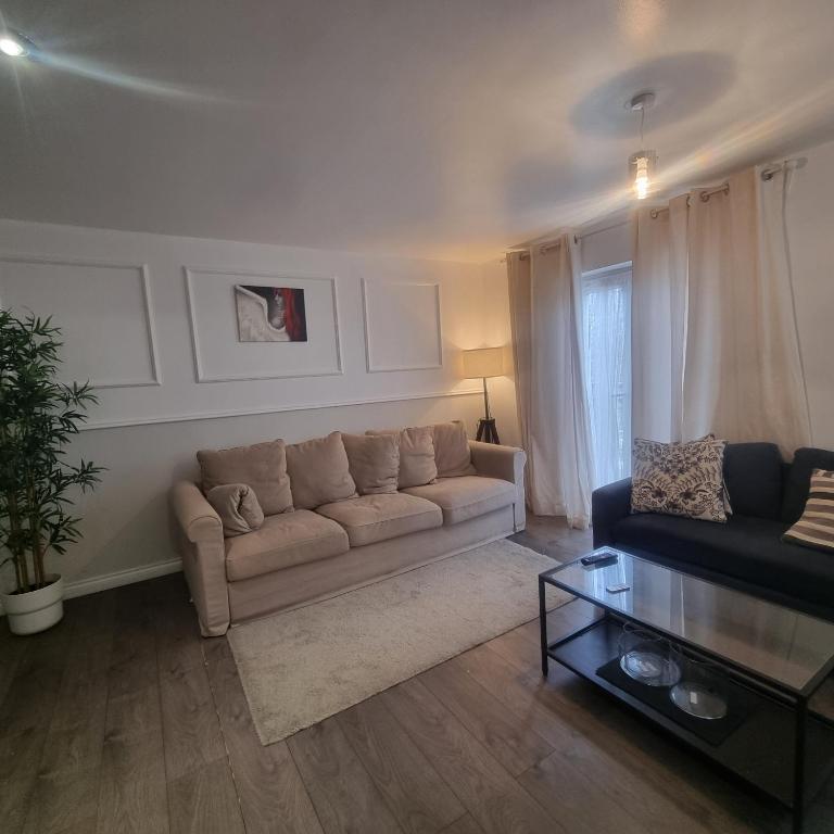 a living room with a couch and a table at Cozy Flat with Parking in Goodmayes