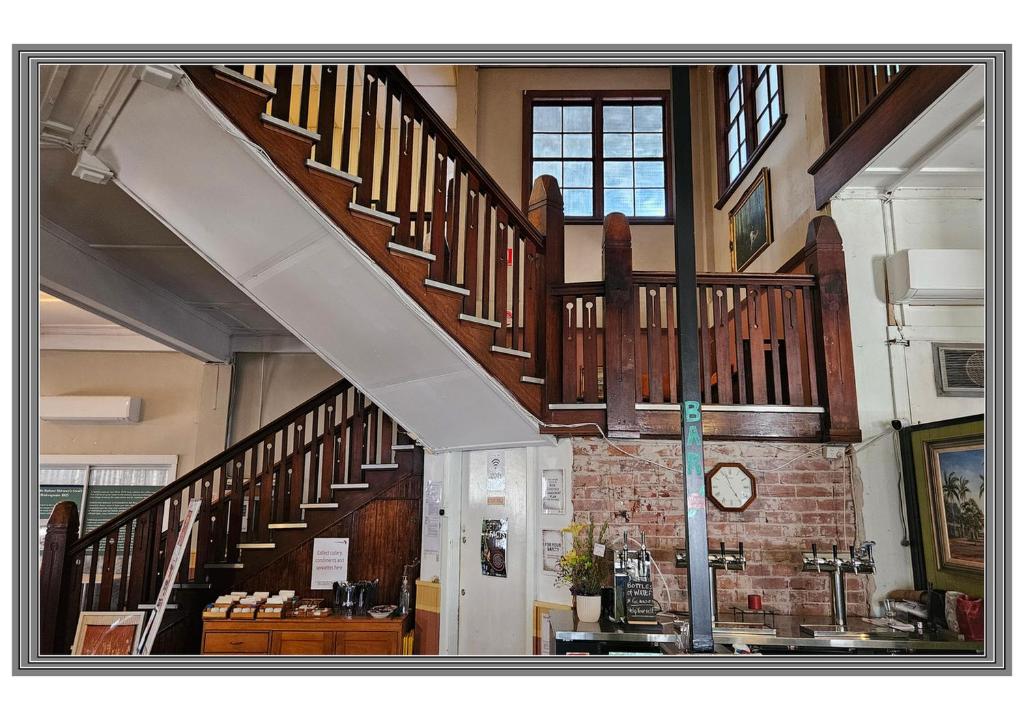 a large room with a staircase in a building at Hotel Shakespeare Barcaldine in Barcaldine