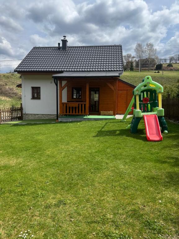 a small house with a playground in the yard at Chalupa Nella II. in Velké Karlovice