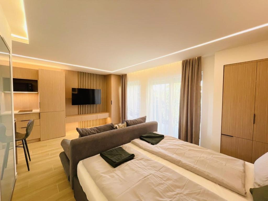 a bedroom with a large bed and a couch at Harbor Hideaway Balatonfüred in Balatonfüred