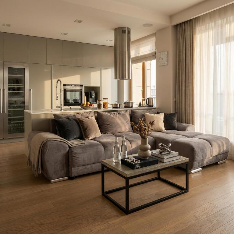 a living room with a large couch and a table at Sky & Spa Luxury Residence in Warsaw