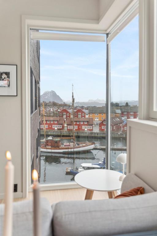 a living room with a large window with a view of a harbor at Exclusive apartment in Lofoten in Svolvær