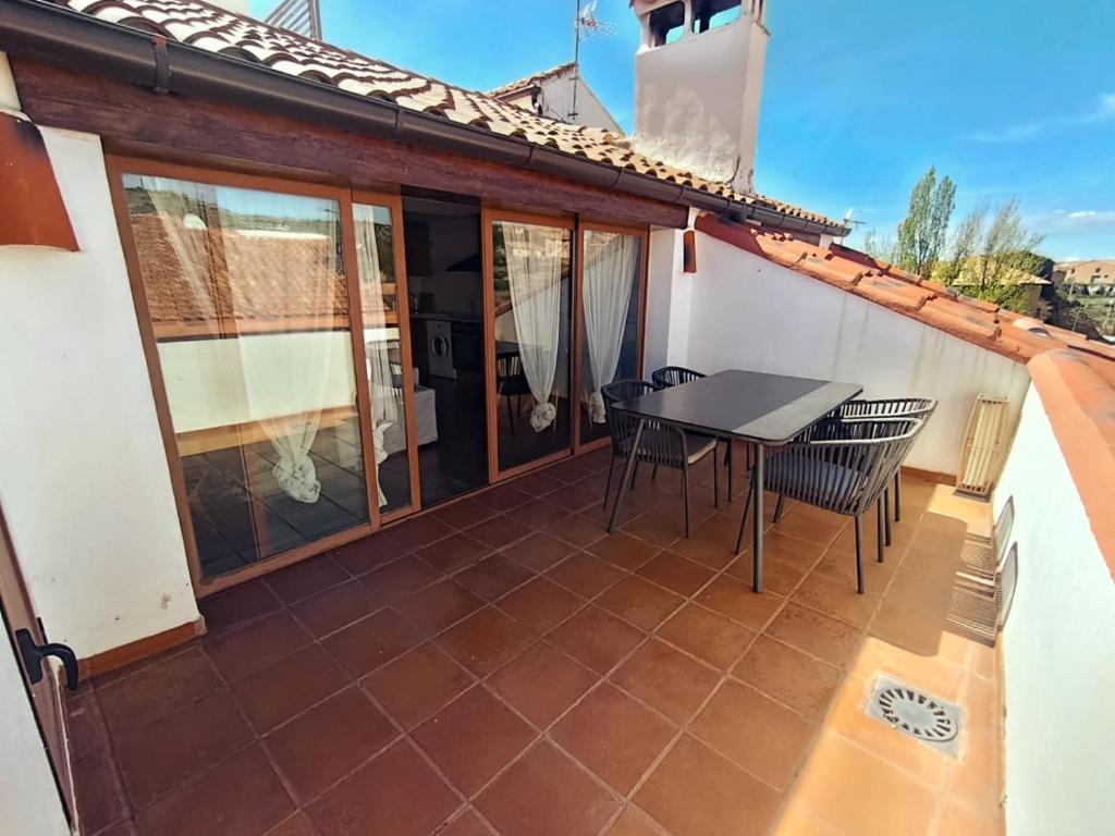 a patio with a table and chairs on a house at Apartamentos Casa Memé in Mora de Rubielos