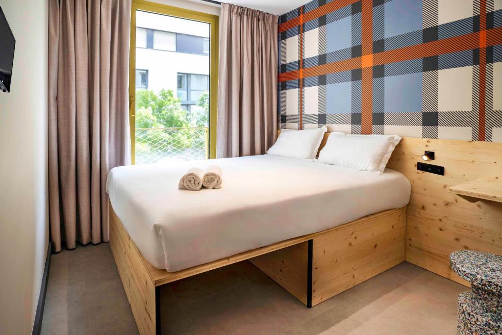 a bedroom with a bed with two slippers on it at easyHotel Marseille Euromed in Marseille