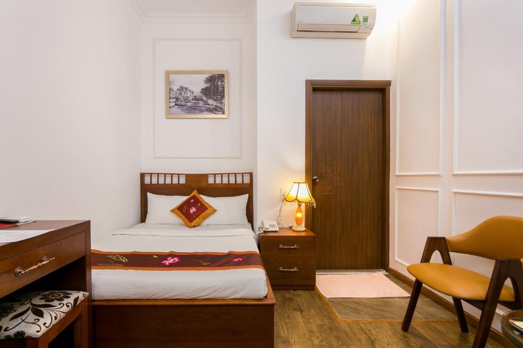 a bedroom with a bed and a desk and a chair at Indochine Apartments in Ho Chi Minh City