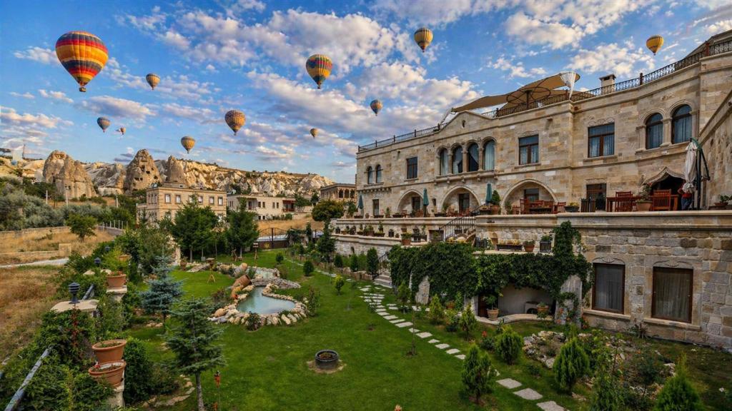 a group of hot air balloons flying over a building at Goreme Inn Hotel Only Adult in Göreme