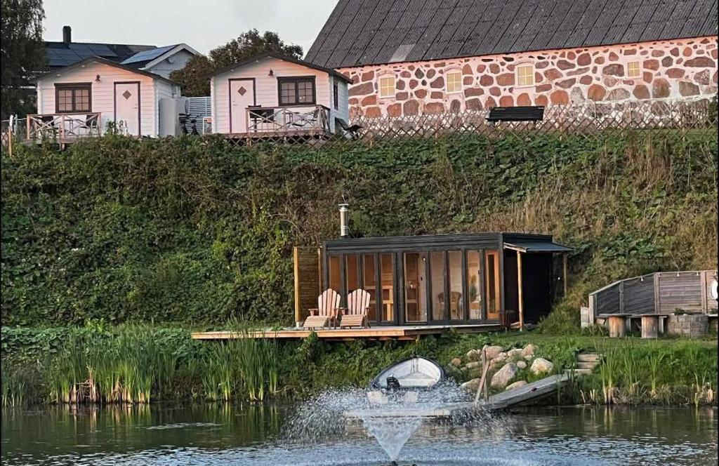 a house on a boat in a body of water at Möllergårdens Stugor in Ängelholm