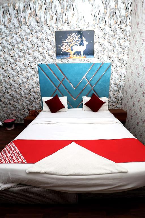 a bedroom with a bed with a red and white blanket at Hotel Hindon Residency "Couple Friendly" in Ghaziabad