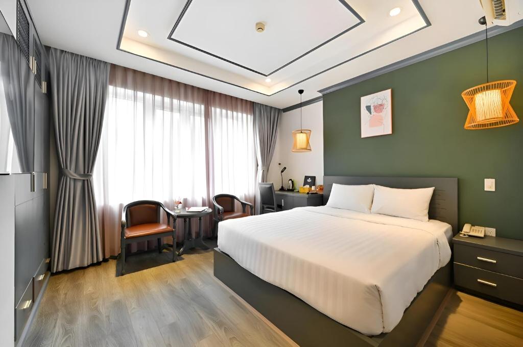 a hotel room with a bed and a table at THE STAR HOTEL - PHU MY HUNG, HO CHI MINH - Korean Buffet Breakfast in Ho Chi Minh City