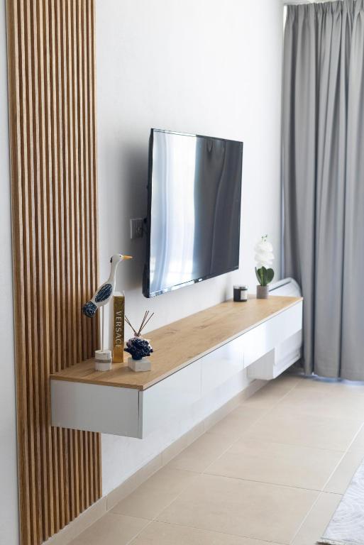 a living room with a tv on a wall at Salt & Serenity Apartment in Orikum