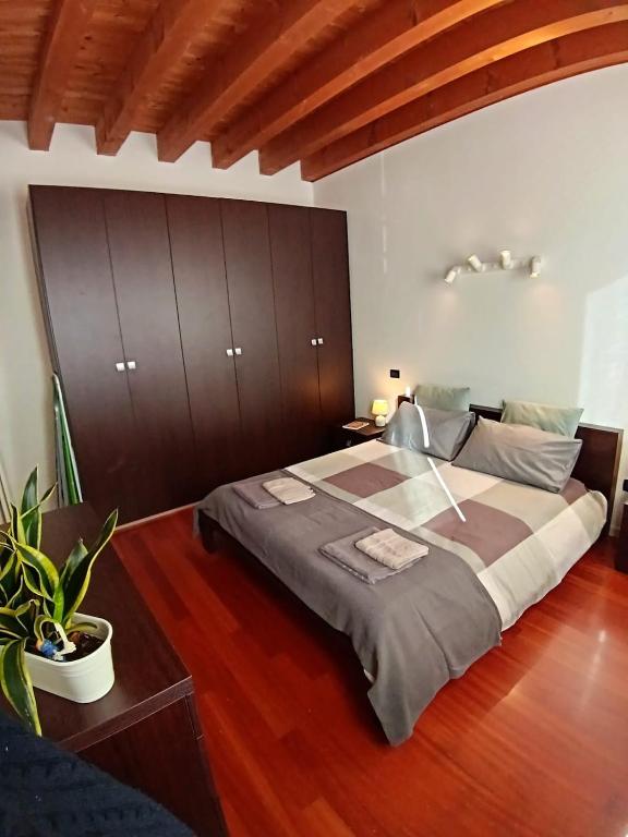 a bedroom with a large bed with a wooden headboard at Dietro la piazza in Marostica