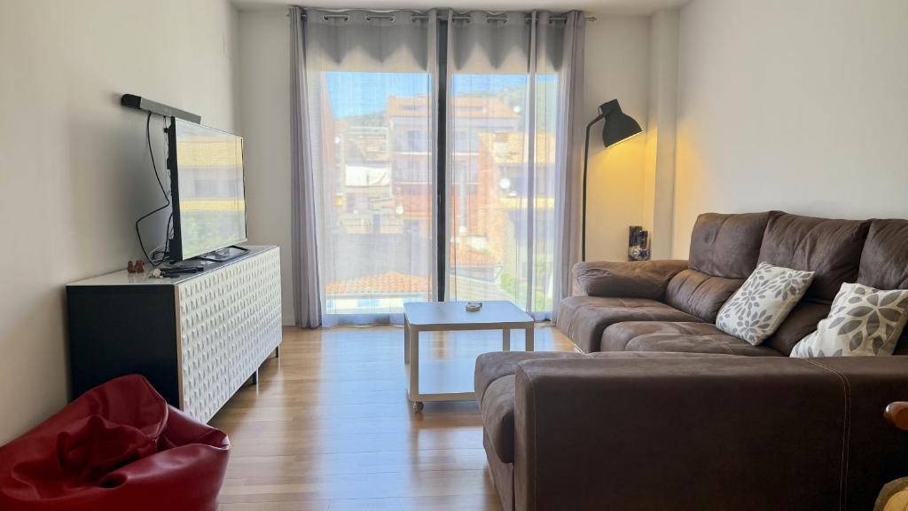 a living room with a couch and a tv at Esglesia 7 2-4 in L'Estartit
