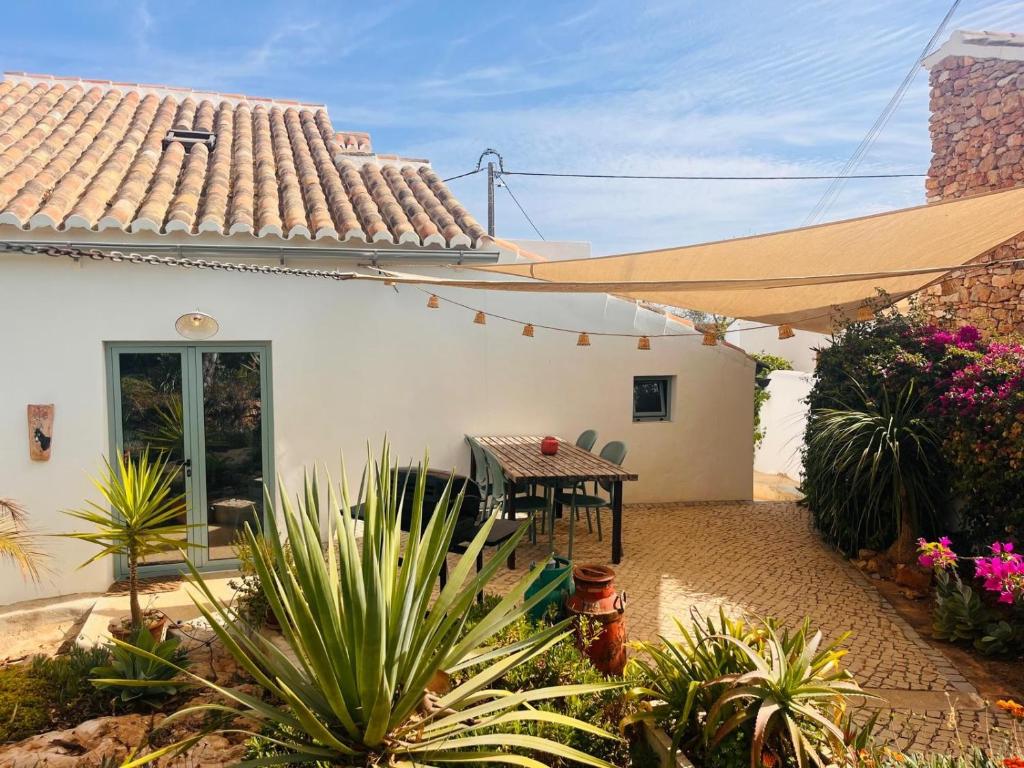 a patio of a house with a table and a tent at Casa Burro in Moncarapacho