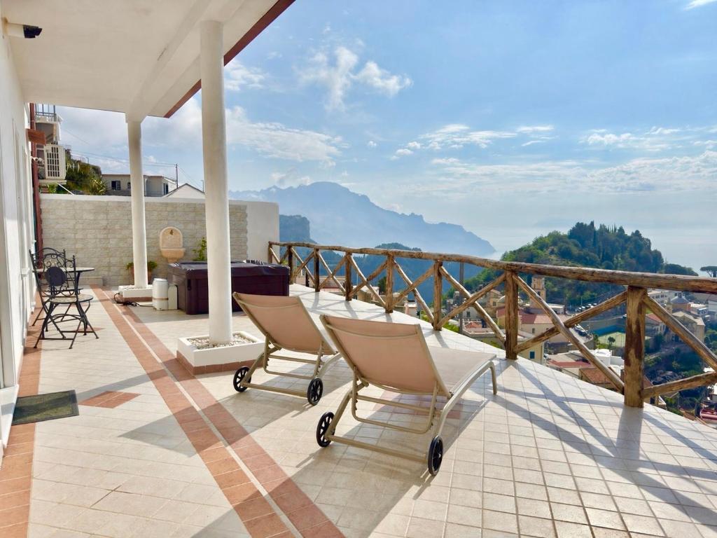 a balcony with chairs and a view of the mountains at Villa Salice in Amalfi