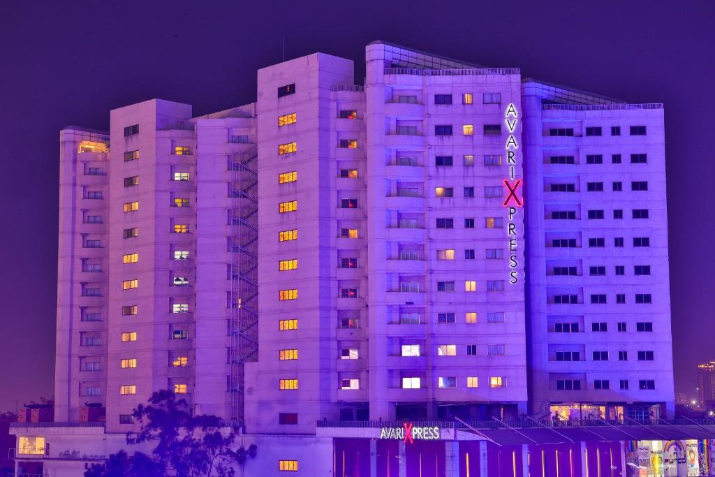 a large white building with lights on at night at Avari Xpress Gulberg in Lahore