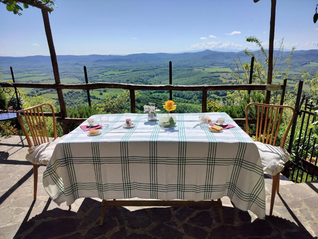 a table with a plate of food and flowers on it at House with stunning views in Chiusdino