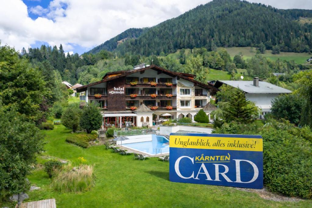 a hotel in the mountains with a sign in the foreground at Hotel Sonnalm - SPA,Idyll,Dining in Bad Kleinkirchheim