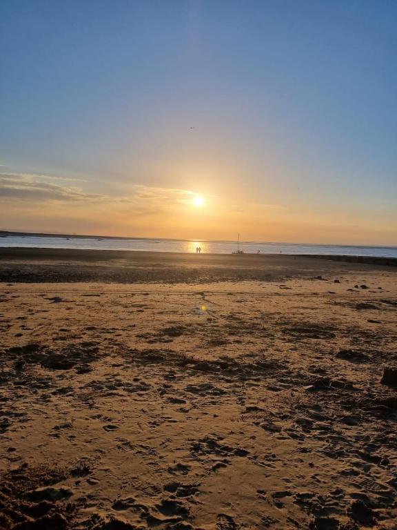 a beach with the sun setting on the horizon at The Pilgrims Cove in Burnham on Sea