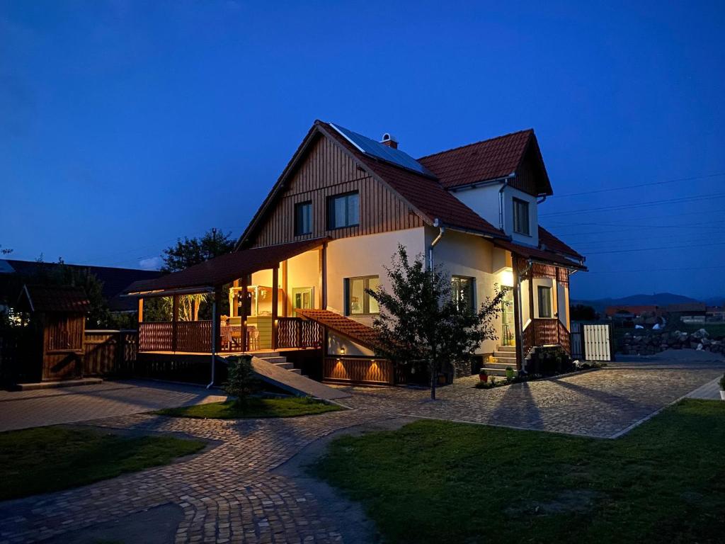 a large house with a roof at night at Mese Szálló in Lăzarea