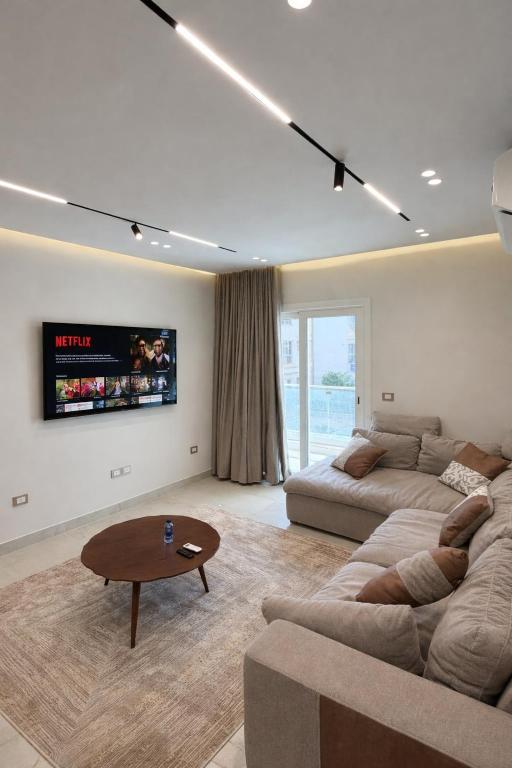 a living room with a couch and a coffee table at Chic Stays Modern 3BR in Mountain View ICITY in 6th Of October