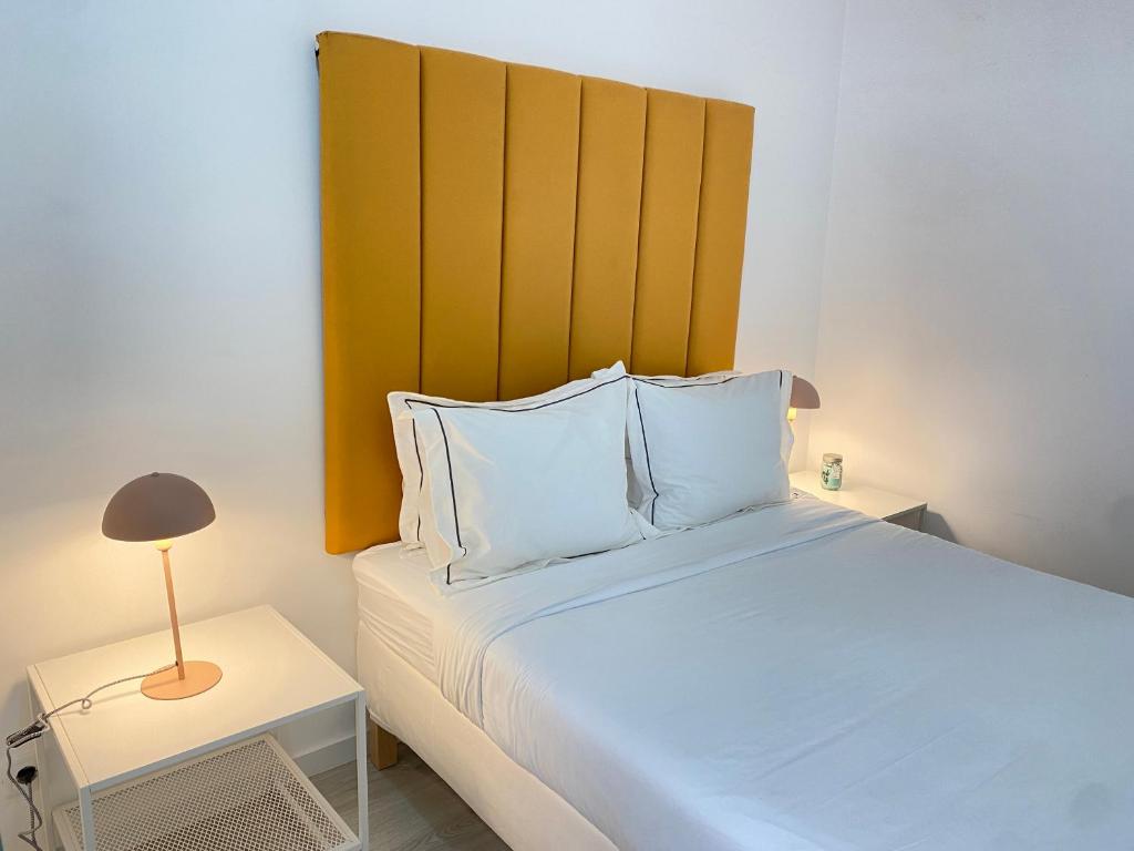 a bedroom with a large bed with a yellow headboard at Vibrant Setúbal II, By Home Match in Setúbal