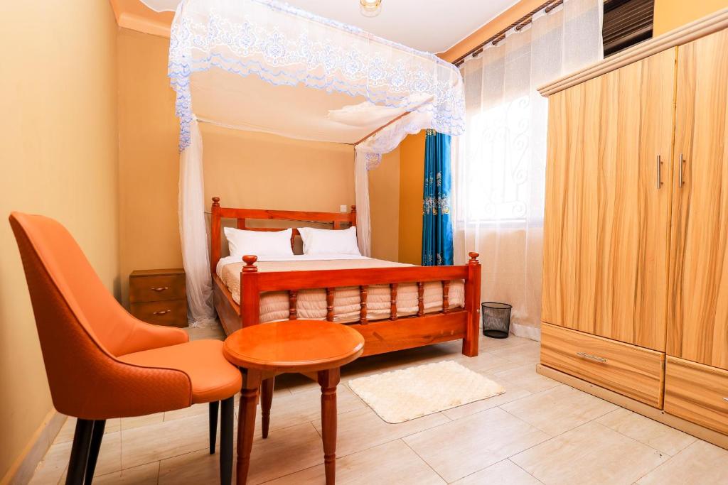 a bedroom with a bed and a table and a chair at EL ROi KADOSHI MOTEL in Kyenjojo