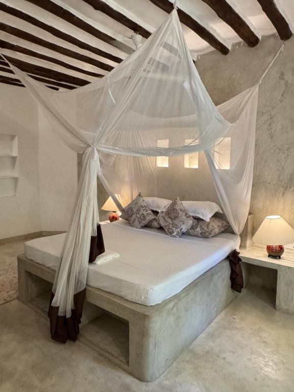 a bed with a mosquito net in a room at Coastal calm apartment in Watamu