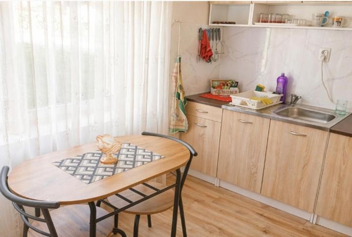 a kitchen with a table and chairs and a sink at Stan na dan ,, Vidovdan ,, in Nevesinje