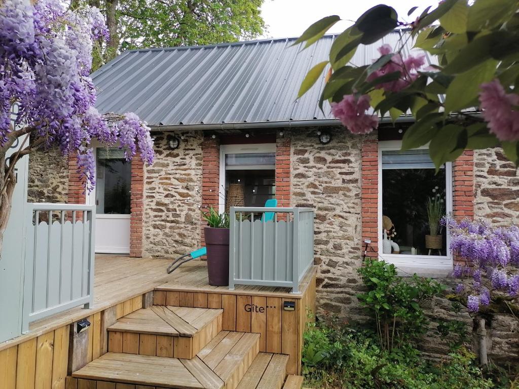 a house with a wooden deck with purple flowers at Gîte classé 3 étoiles - Morlaix in Morlaix