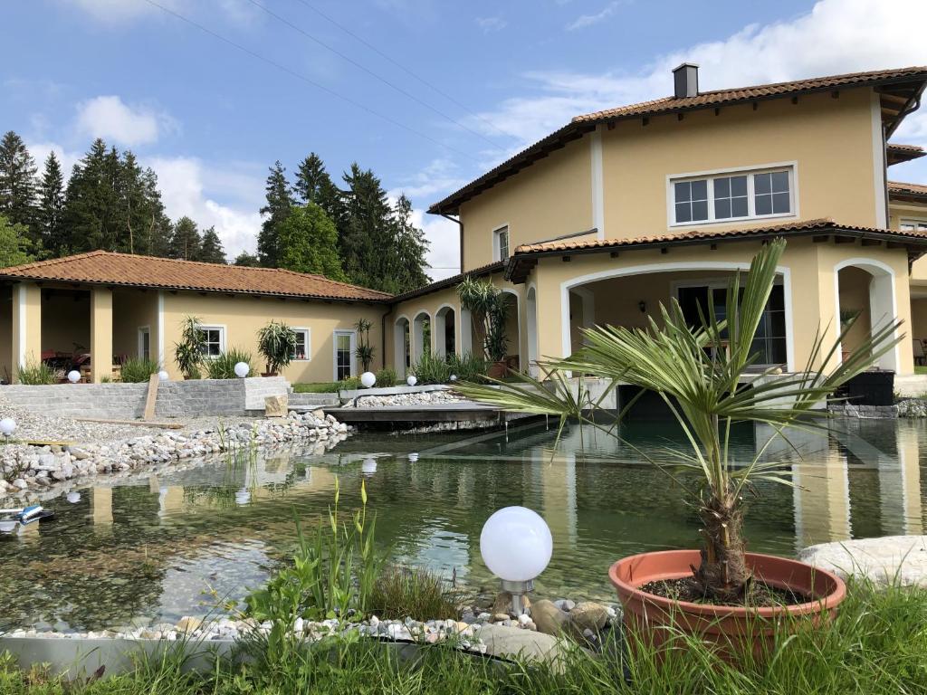 a house with a pond in front of a house at Die Haas-Villa in Berg