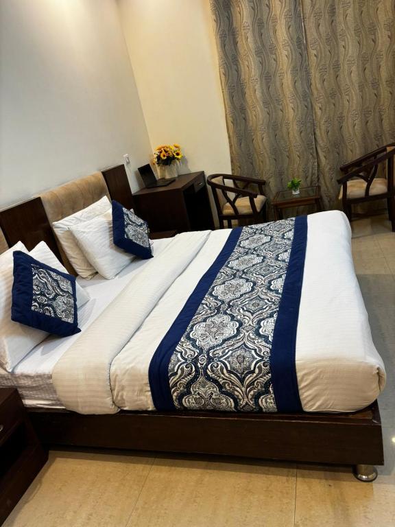 a bed with blue and white blankets and pillows on it at VR Residency 83 in Gurgaon