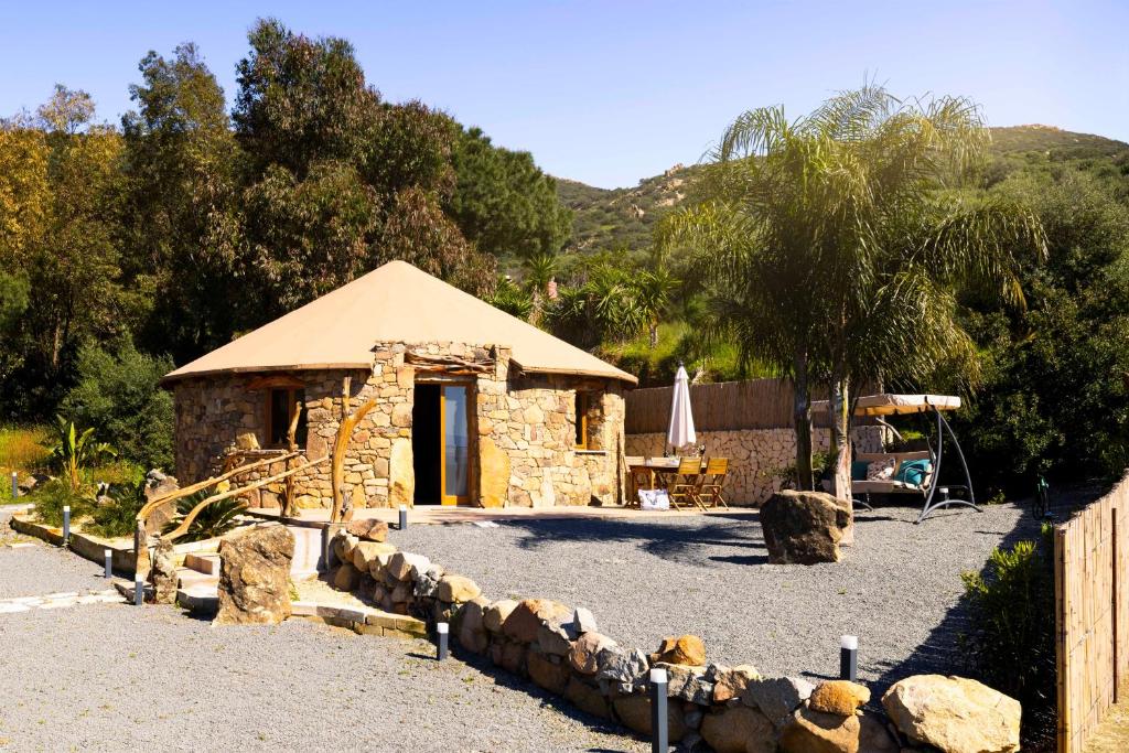 a small stone building with a tree and a fence at Pinnettu Sa Rosa - Jacuzzi & Relax Deluxe in Quartu SantʼElena