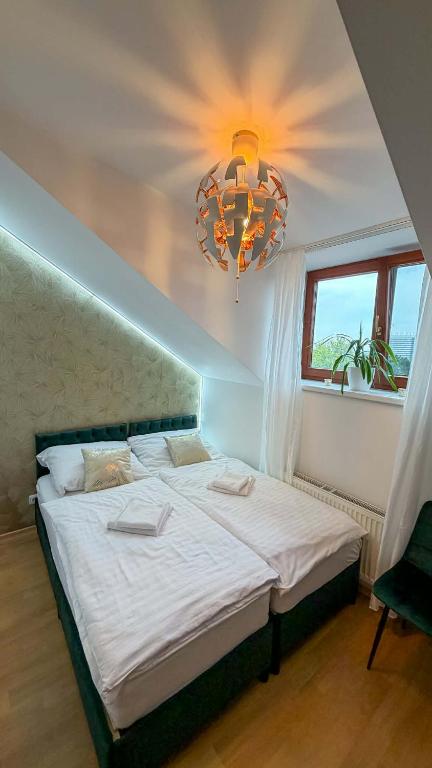 a bedroom with a large bed and a chandelier at Penzion Navara in Kolín