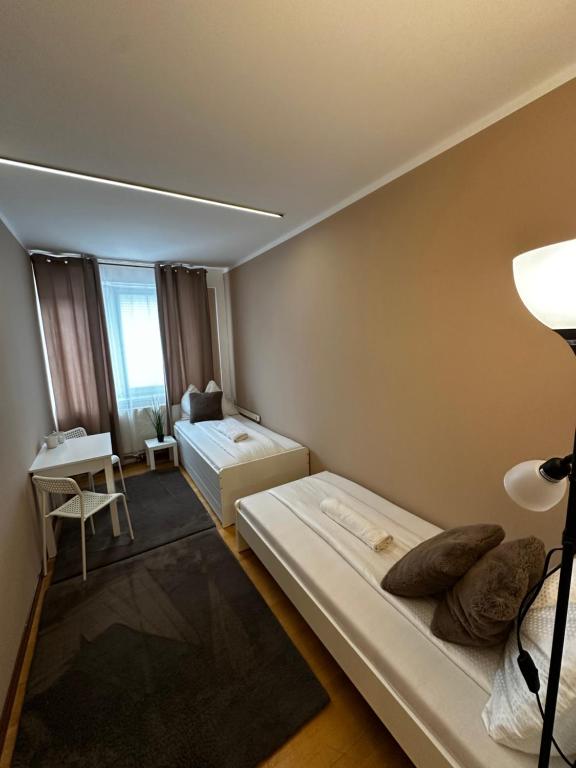 a small room with two beds and a table at Zimmervermietung Linz 1 in Linz