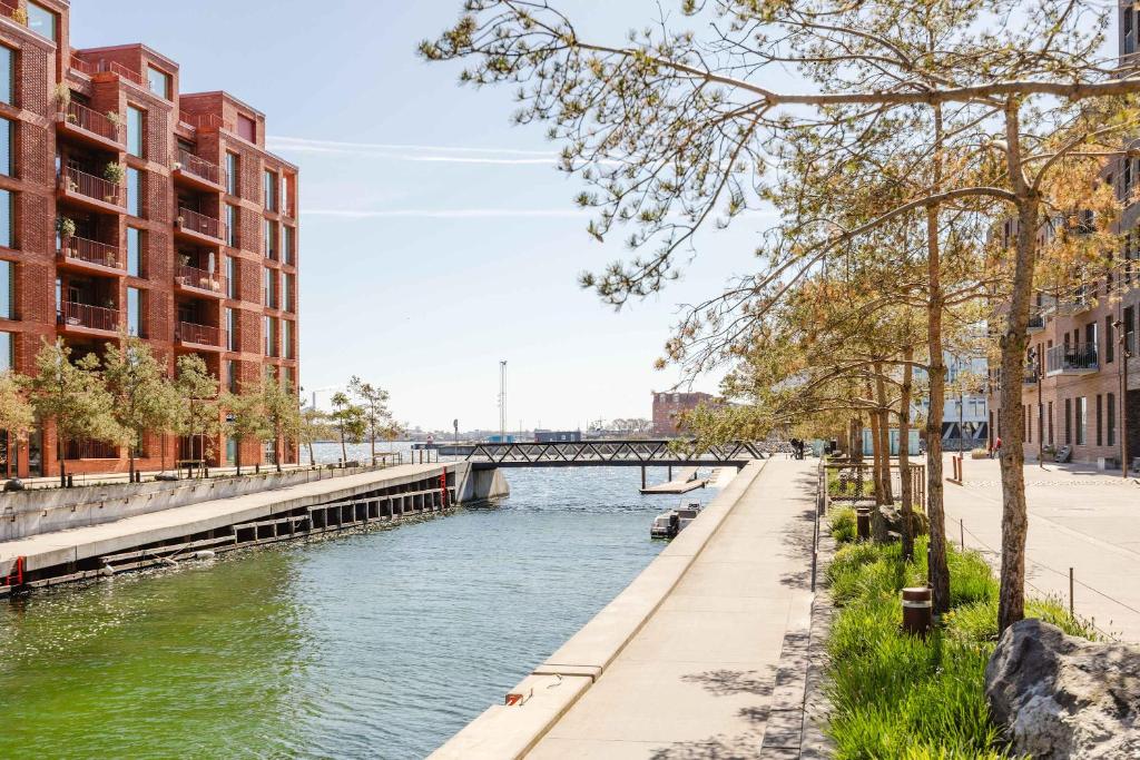 a river in a city with buildings and a bridge at Exclusive in Copenhagen