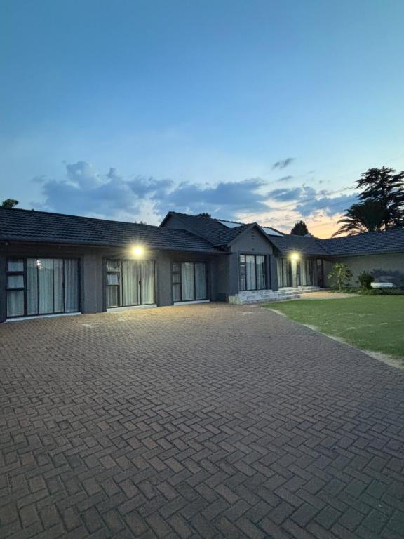 a house with a brick driveway in front of it at Randhart guesthouse in Alberton