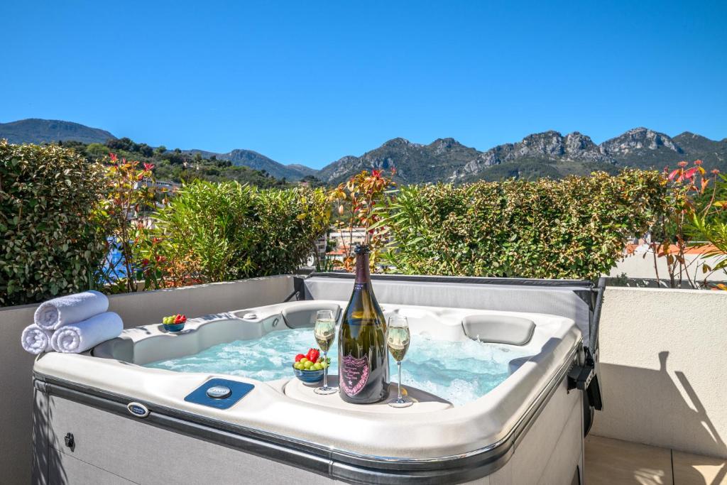 a hot tub with a bottle of wine and glasses at Le Coq Elysium - Exceptional 220 sqm Penthouse - Private Terrace & Jacuzzi - AC - 3 Parking Spaces in Menton