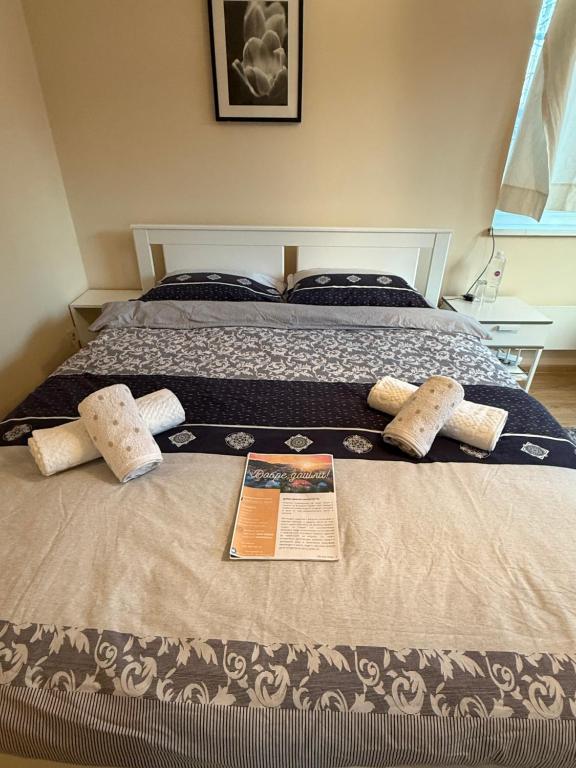 a bed with two pillows and a book on it at The Cozy House in Kyustendil